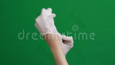 女医生戴上白手套。 铬键背景。 女医生戴上无菌手套。 实验室